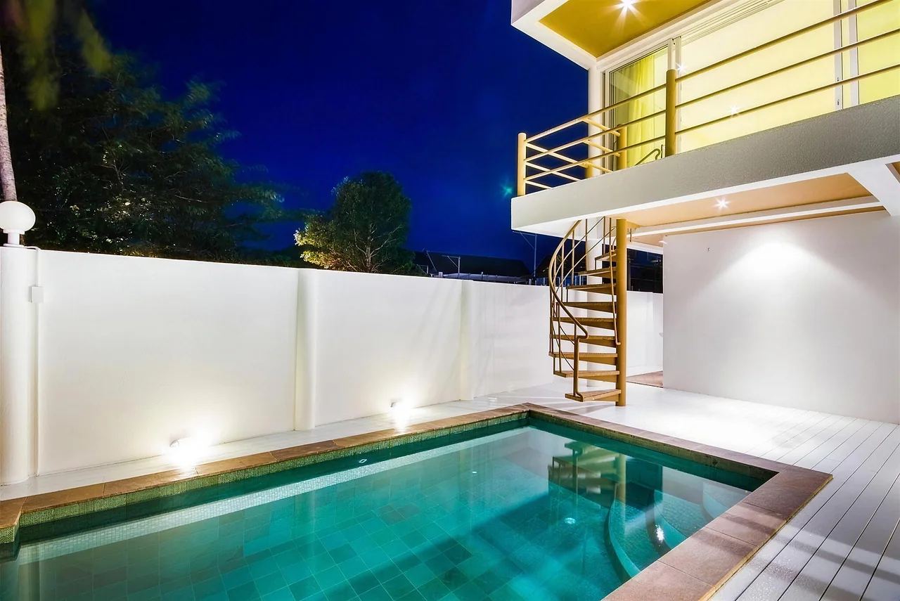 The pool at night below the lit terraces